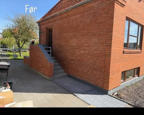 Rød murstensfacade med gavl og udvendig trappe før facadearbejde